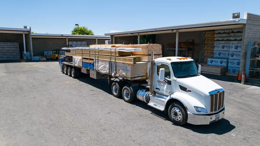 Colonial flatbed truck loaded with lumber leaving the Centerville yard for delivery
