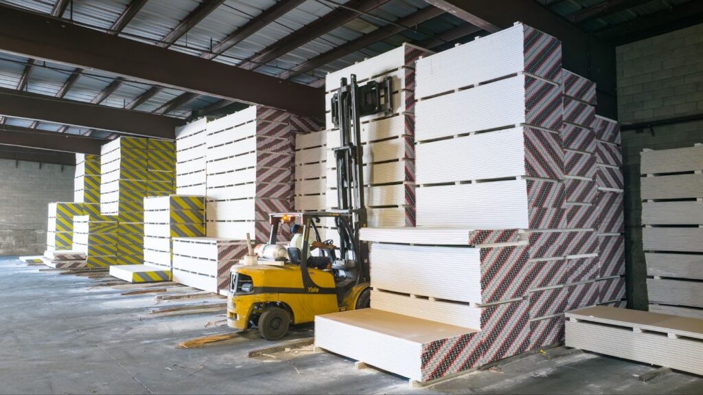 Forklift loading stacked drywall sheets in Northern Utah warehouse